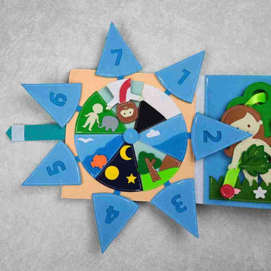 Children’s felt Activity Books page in blue and peach, with a rotating numbered wheel and colorful animal and nature appliqués.