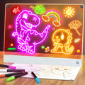 Activity Books light-up drawing board in clear acrylic, glowing with colorful dinosaur, rainbow, sun and flower drawings