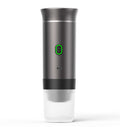 Automatic Capsule Espresso maker in metallic gray with a tall cylindrical body, green-lit power button and clear cup base