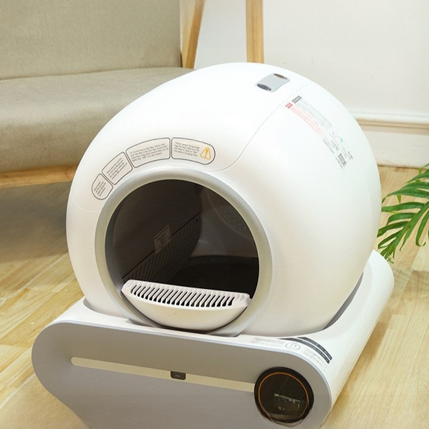 Automatic Pet Litter Box in smooth white plastic, with a rounded enclosed shell, large circular entrance and dark control dial.