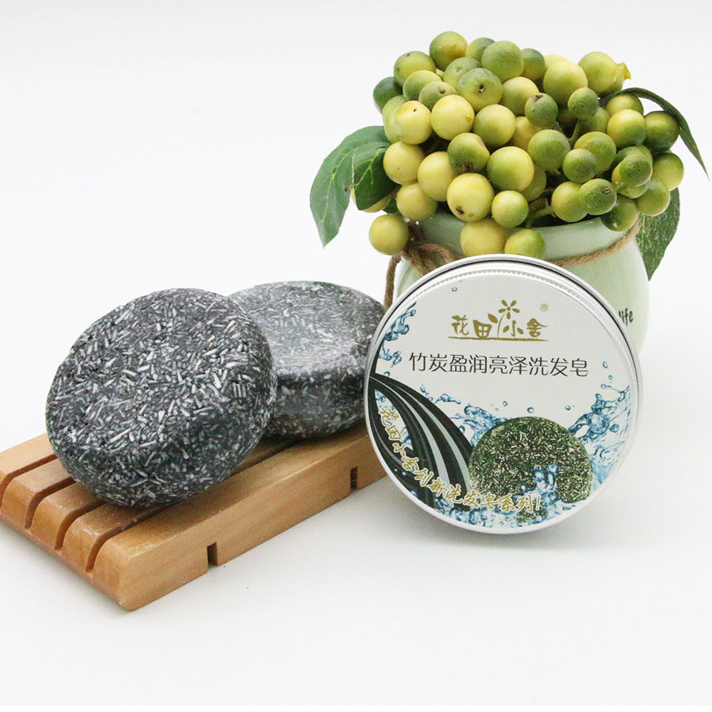 Bamboo Charcoal Shampoo Soap Bar, dark gray speckled solid bars beside a round tin with botanical label.