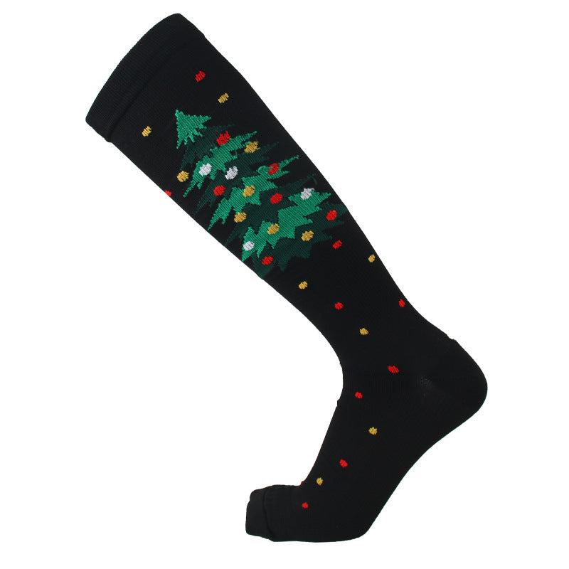 Christmas Compression Socks in black stretch knit with a green Christmas tree pattern and scattered colorful festive motifs