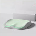 Cushion to prevent buttock pain with a pale green contoured top, gray memory foam base, and glowing green edge