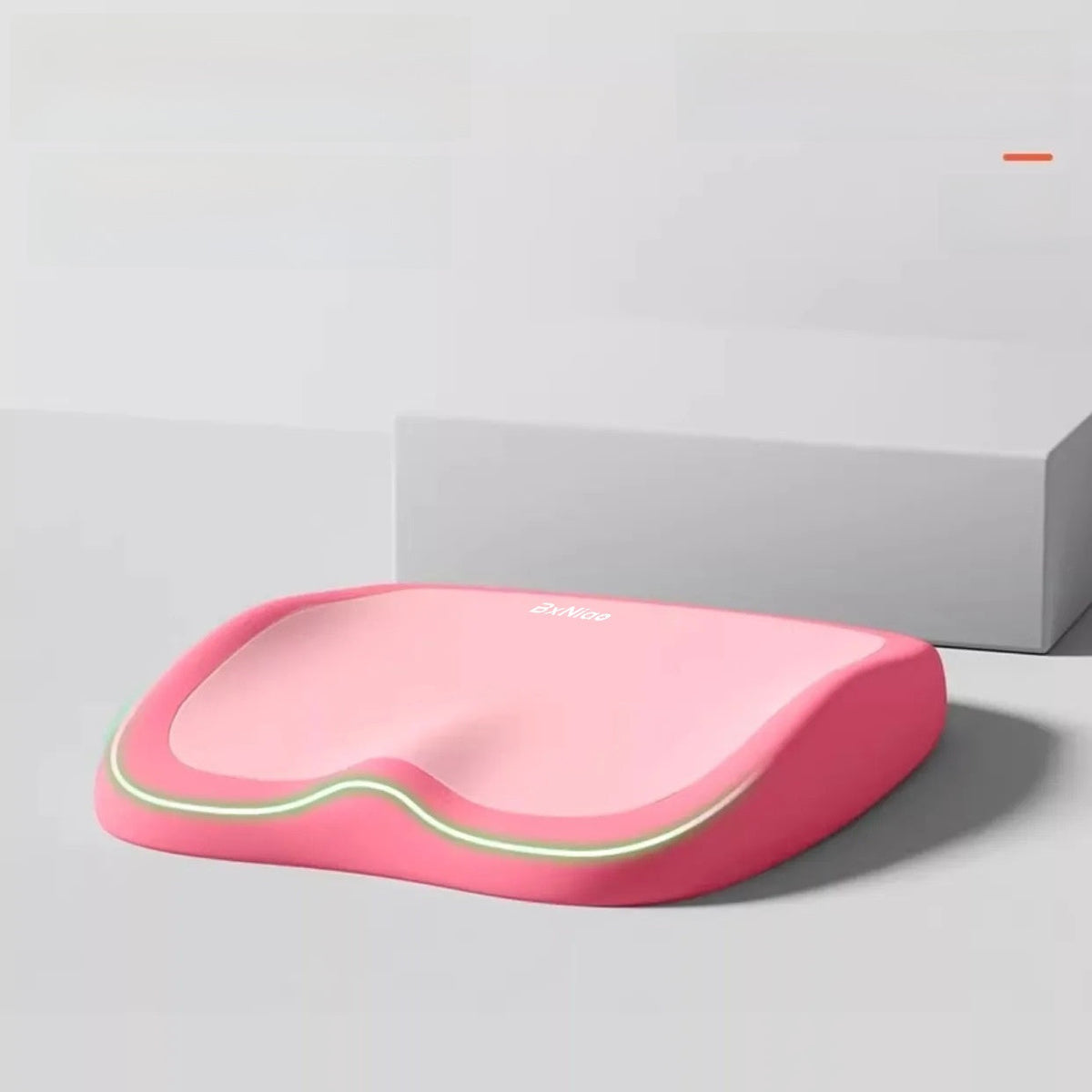 Cushion to prevent buttock pain in pink memory foam with a pale contrasting front trim and contoured seat shape