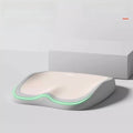 Cushion to prevent buttock pain in white memory foam with a contoured seat shape and glowing green edge