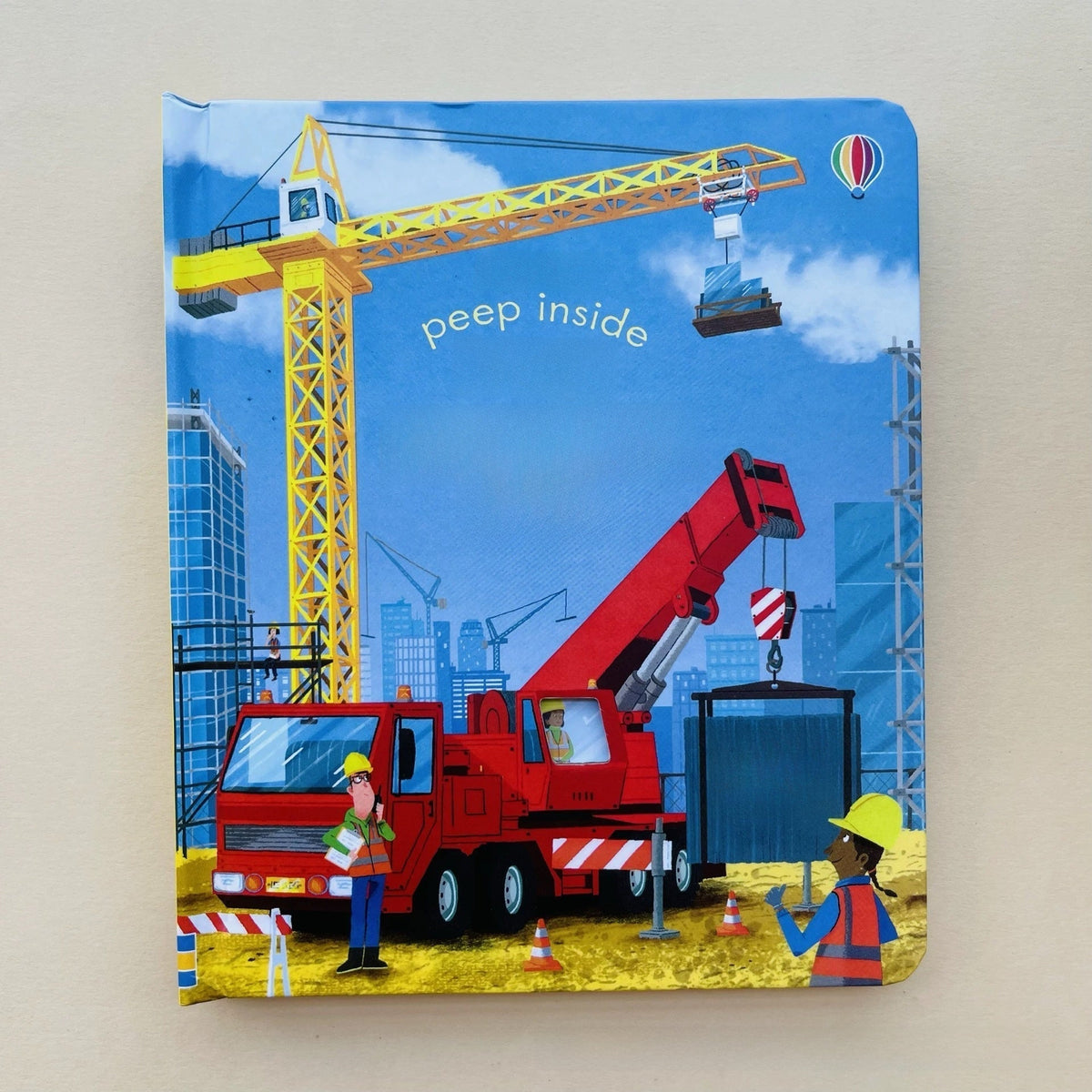 Peek-through Educational  Picture Books construction-themed board book with a bright blue cover, cranes and workers in vivid illustrations