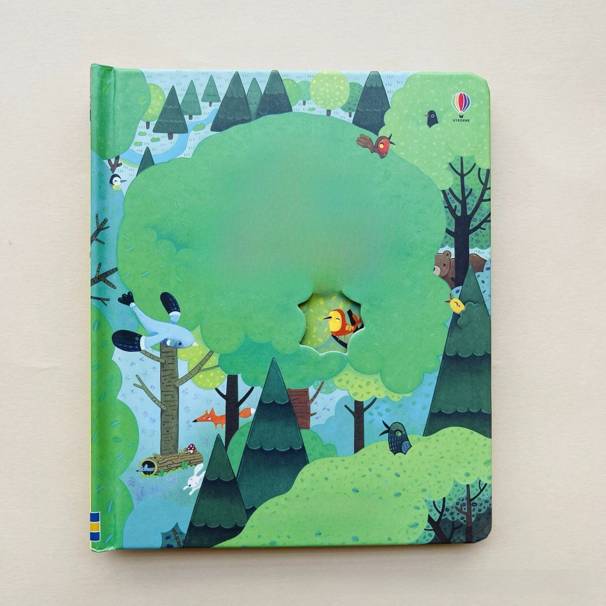 Peek-through children’s picture book in green, with forest animals and a die-cut opening; Educational  Picture Books.