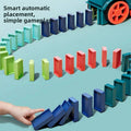 Electric Domino Train Toy with a teal plastic locomotive and bright orange wheel placing rows of colorful upright dominoes