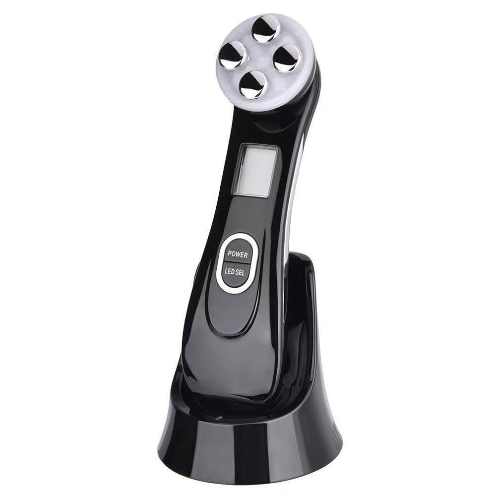 Facial Beauty Device in glossy black with a silver four-point treatment head, display screen, power buttons and charging stand