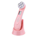Facial Beauty Device in glossy pink with a rounded four-contact metal treatment head, small display, and matching charging base