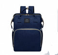 Foldable Baby Bed carry bag in dark navy blue fabric with multiple zippered compartments, top handles and shoulder straps