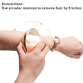 Glass Frosted Exfoliator with a smooth reflective gold-toned surface held against an arm for circular hair removal