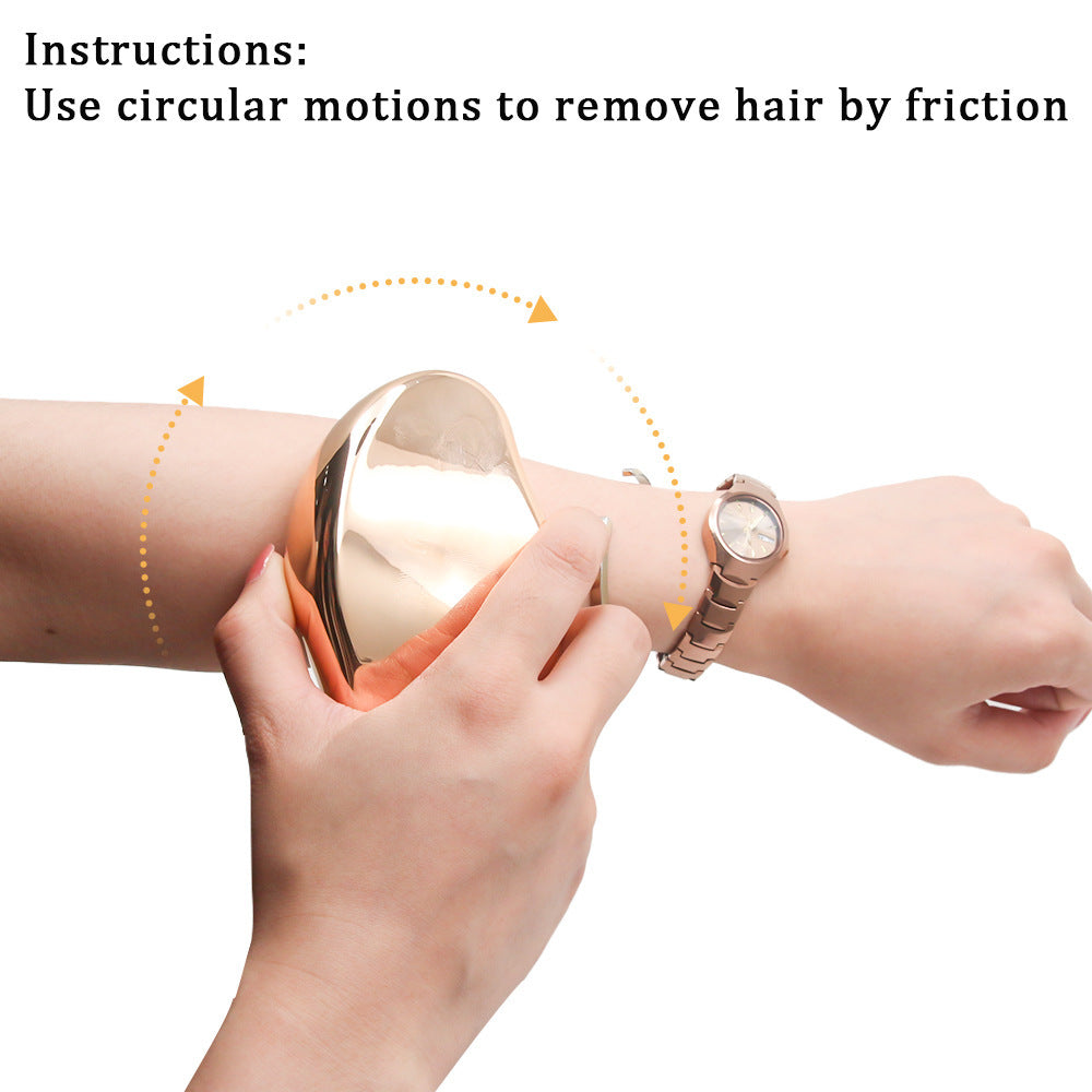 Glass Frosted Exfoliator with a smooth reflective gold-toned surface held against an arm for circular hair removal