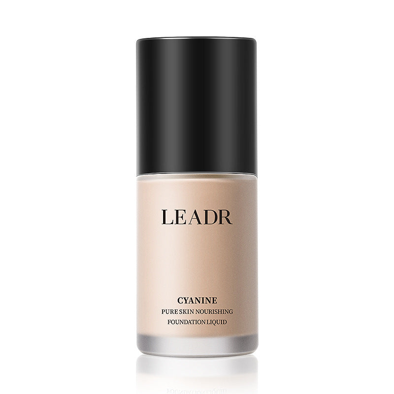 Goddess Beauty Pure Beauty liquid foundation in a beige bottle with a black cap and silver base, labeled LEADR