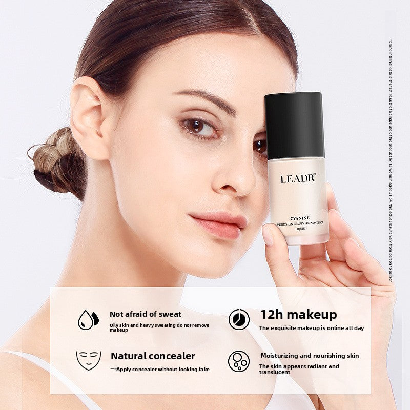 Goddess Beauty Pure Beauty liquid foundation bottle with black cap, white and blush pink packaging, shown beside a model