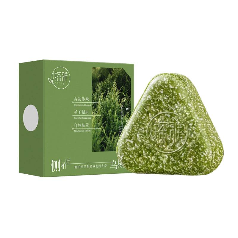 Hair Strengthening Soap in a green-and-white herbal bar with speckled texture, paired with green packaging featuring cypress leaves
