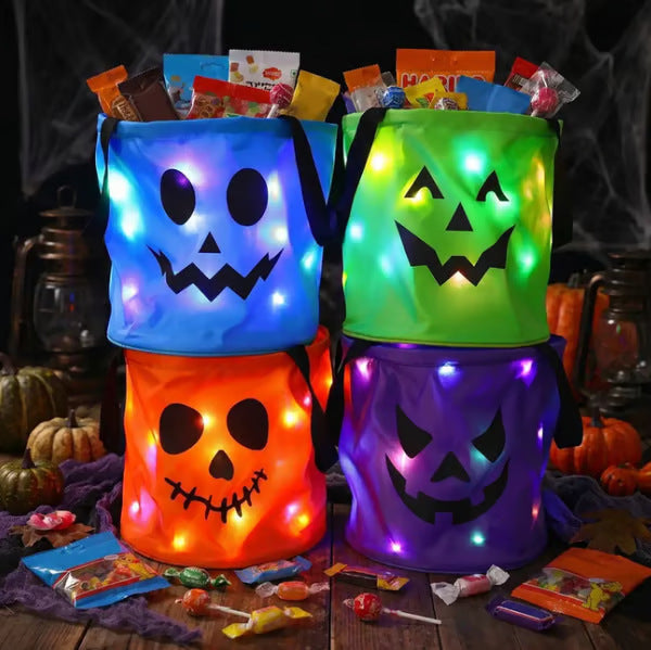 Halloween LED Glow Candy Basket, colorful cloth buckets in green, orange, purple, and blue with glowing jack-o’-lantern faces and handles
