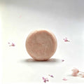 Herbal soap bar in pale blush pink with a rounded shape and softly textured, handmade-looking surface
