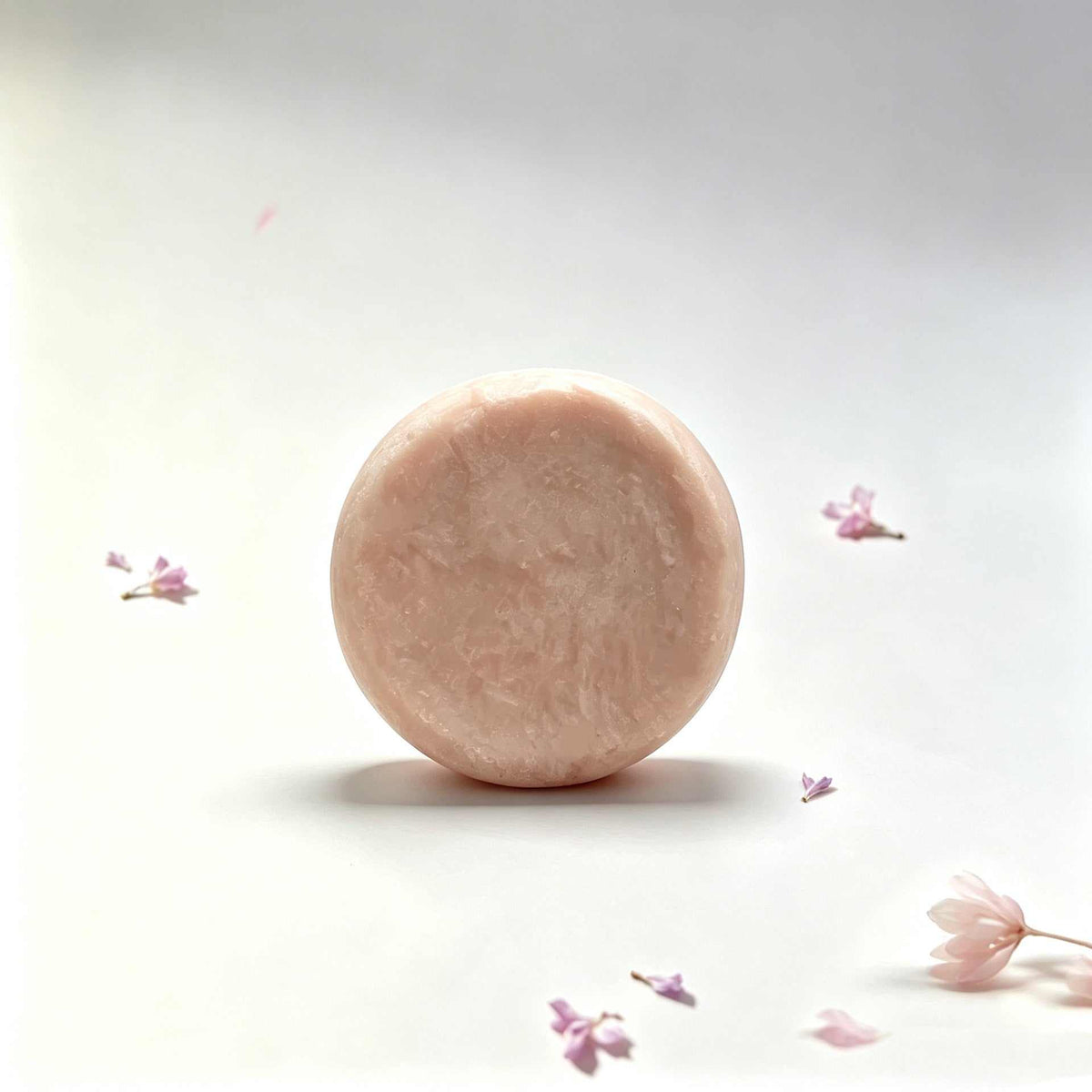 Herbal soap bar in pale peach with a round shape, subtly marbled texture, and smooth handmade edges