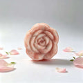 Herbal soap in a pale pink and cream rose shape, with a softly marbled finish and sculpted petal details