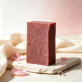 Herbal soap bar in muted rose-pink with a marbled, handmade-looking surface and clean rectangular edges