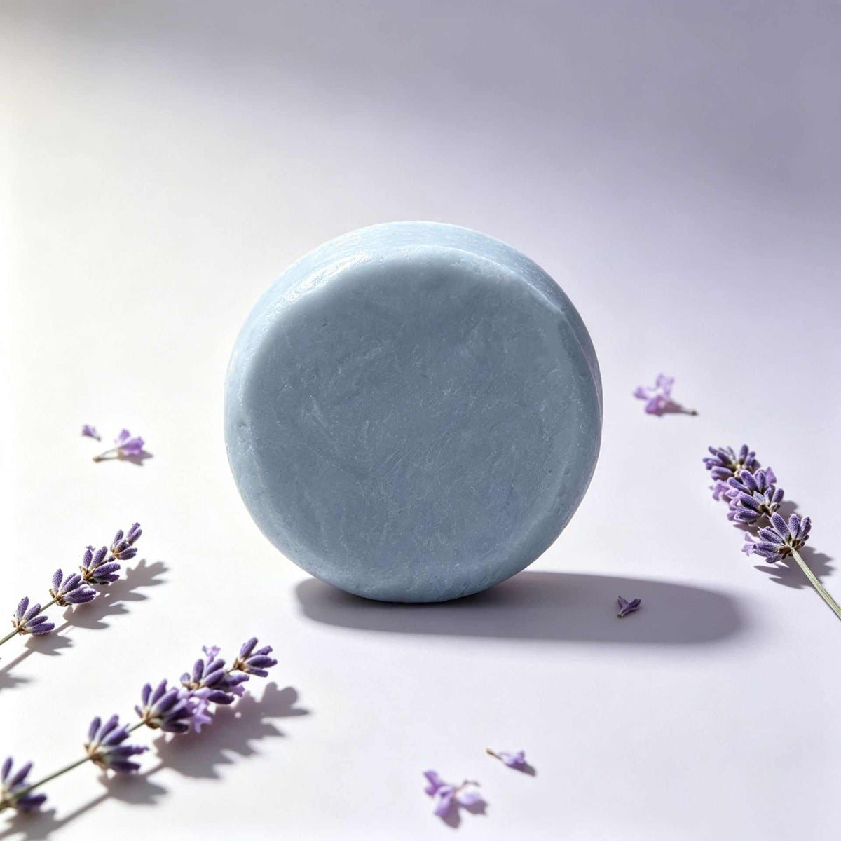 Herbal soap in a smooth, round pale blue bar with a solid, unpatterned surface and gently curved edges