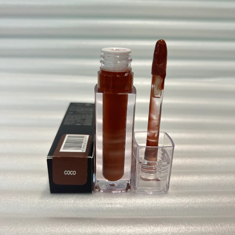 Huda Beauty Moisturizing lip gloss in a clear rectangular tube, shown in a deep brown shade with matching applicator and box