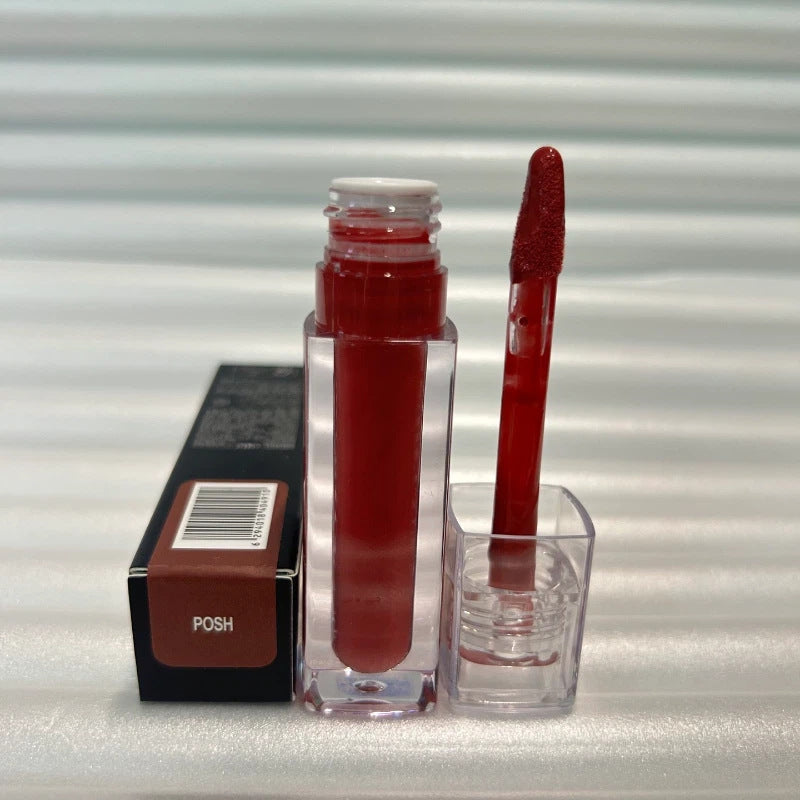 Huda Beauty Moisturizing lip gloss in deep red, shown in a clear rectangular tube with a matching applicator wand