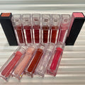 Huda Beauty Moisturizing lip gloss set with clear rectangular tubes in assorted rosy, nude, red and brown shades