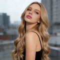 Long Curly Synthetic Wigs with long, blonde hair, a center part, and loose, voluminous waves in a natural-looking style