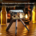 Magnetic Phone Holder Stand in black and silver metal, with three foldable legs supporting a phone in landscape orientation