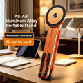 Magnetic Phone Holder Stand in orange aluminum alloy, with a round black magnetic pad and slim foldable support rails.