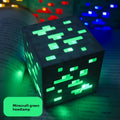 Minecraft Ore lamps cube lamp with a dark pixelated surface and bright green glowing ore shapes on each visible side