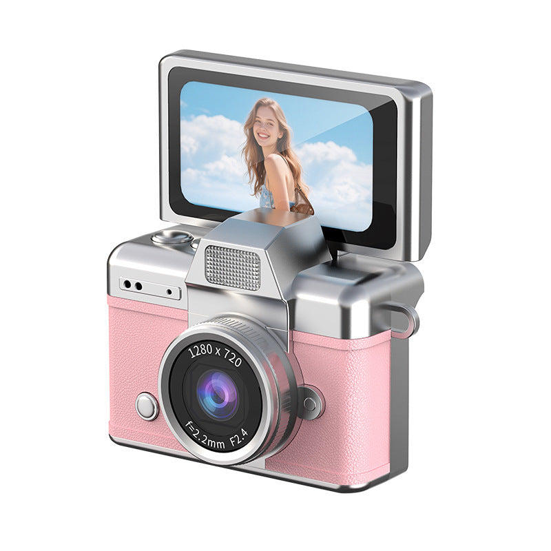 Miniature Digital Camera with a pink textured body, silver trim, prominent lens and raised flip-up display