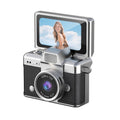 Miniature Digital Camera with a silver and black plastic body, textured grip, prominent lens and flip-up screen