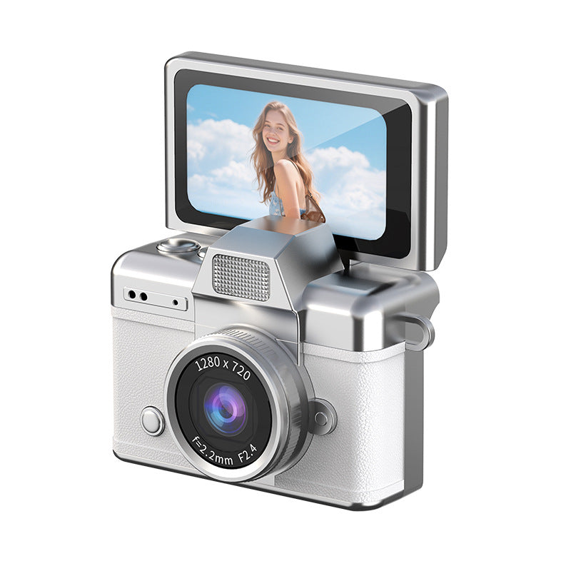 Miniature Digital Camera in silver and white textured plastic, with a large lens, black trim and a flip-up screen