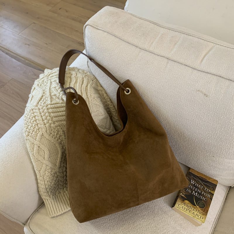 Minimalist Retro Suede shoulder bag in dark brown with a soft, plain finish, wide bucket shape, and single strap attached by metal rings.