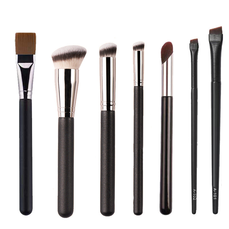 Professional Makeup Brush Set with seven black-handled brushes, silver ferrules, and varied brown and white bristle shapes for precise application.