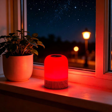 Red Light Therapy Lamp with a glowing red cylindrical shade and wood-grain base, featuring a touch control top