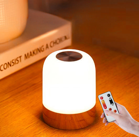 Red Light Therapy Lamp with a glowing white dome, wood-look base and touch-sensitive controls on top.