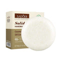 Shampoo Bar as a round, off-white solid with a rough textured surface, displayed beside cream and olive packaging
