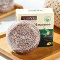 Shampoo Bar in a round brown-and-cream speckled solid form, shown with a cream and green SADOER shampoo box