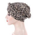 Headscarf cap in beige polyester with black leopard spots and short braid detail; Short braids can be hidden beneath it.