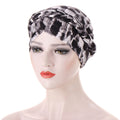 Headscarf cap with a black, gray, and white abstract print, featuring braided trim around the crown; Short braids can be hidden