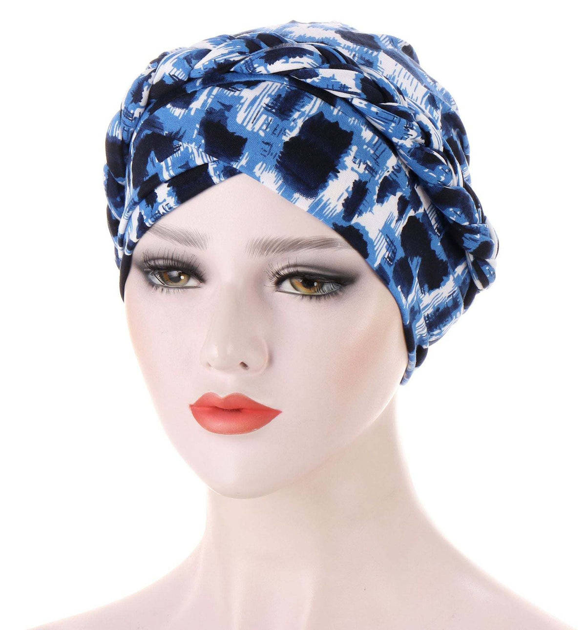 Headscarf cap in blue and white abstract print, gathered and twisted into a soft turban style; Short braids can be hidden