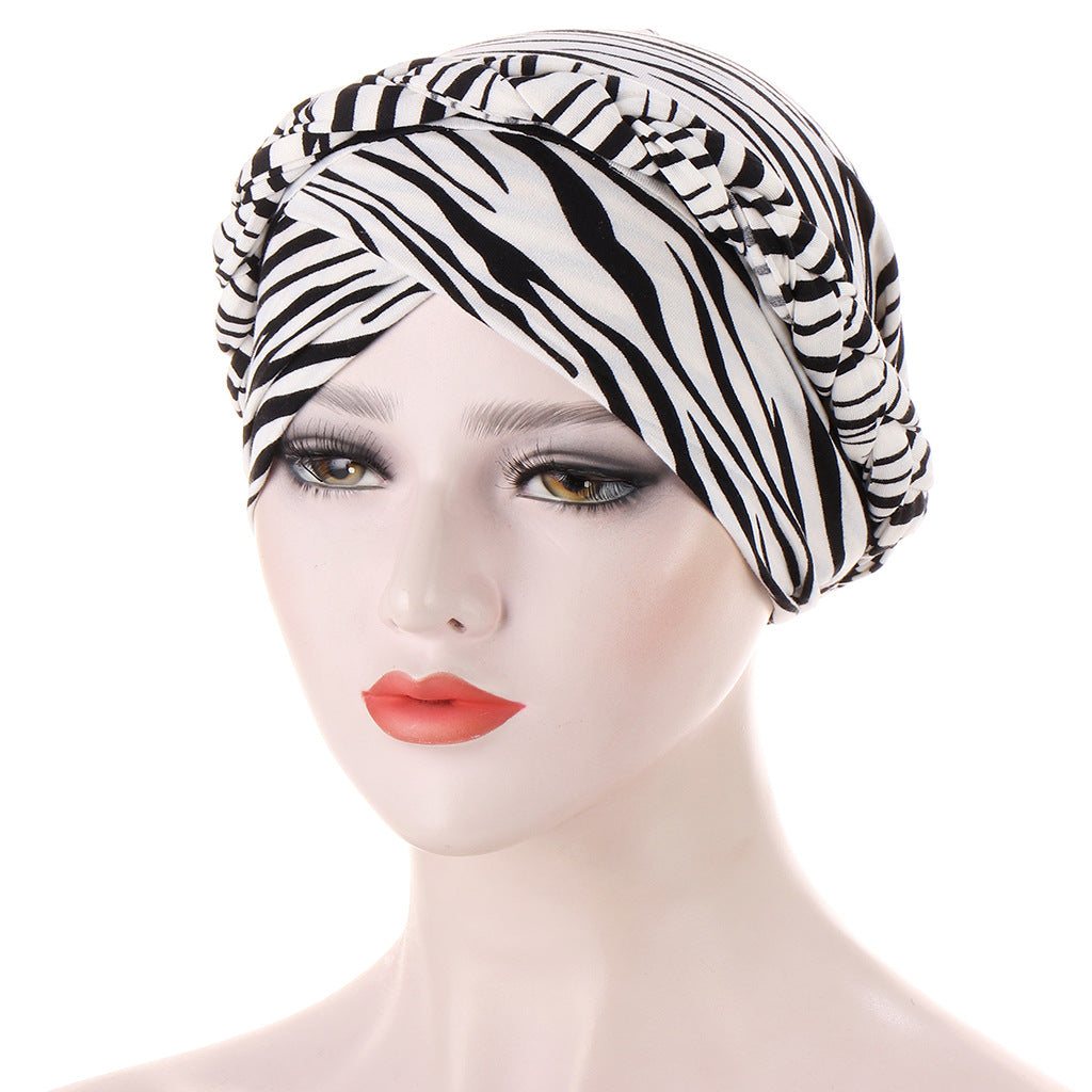 Headscarf cap in black and white zebra-striped polyester, with gathered folds and a wrapped turban-style front; Short braids can be hidden