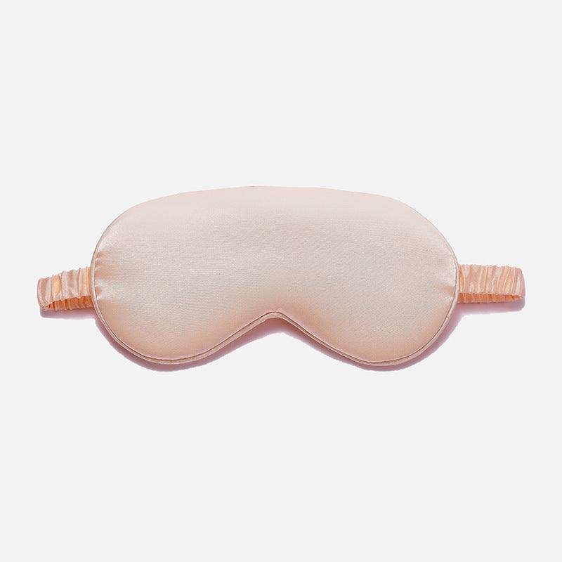 Simulated Silk Sleep Eye Mask in pale peach pink with a smooth fabric surface, contoured shape and gathered elastic strap