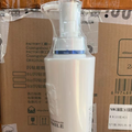 Smoothing Shampoo in a white bottle with a clear pump dispenser and blue band near the neck
