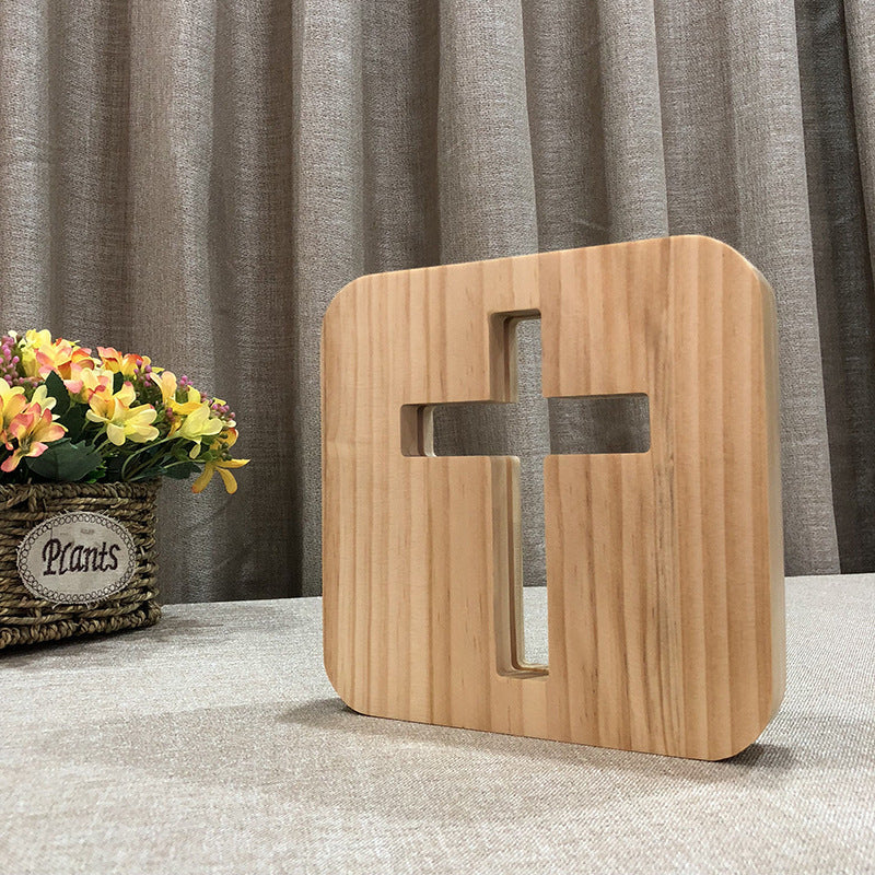 Solid Wood LED night lamp in natural light wood, with a rounded square face and geometric cross-shaped cutout.