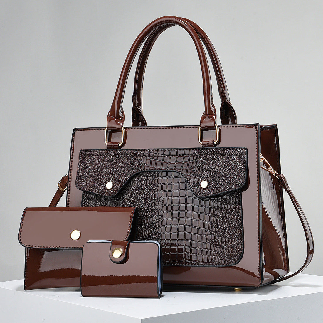 Three-piece handbag set in dark brown faux leather, with croc-textured front pocket, glossy finish and matching wallets; Specialized Design Leather Bags.